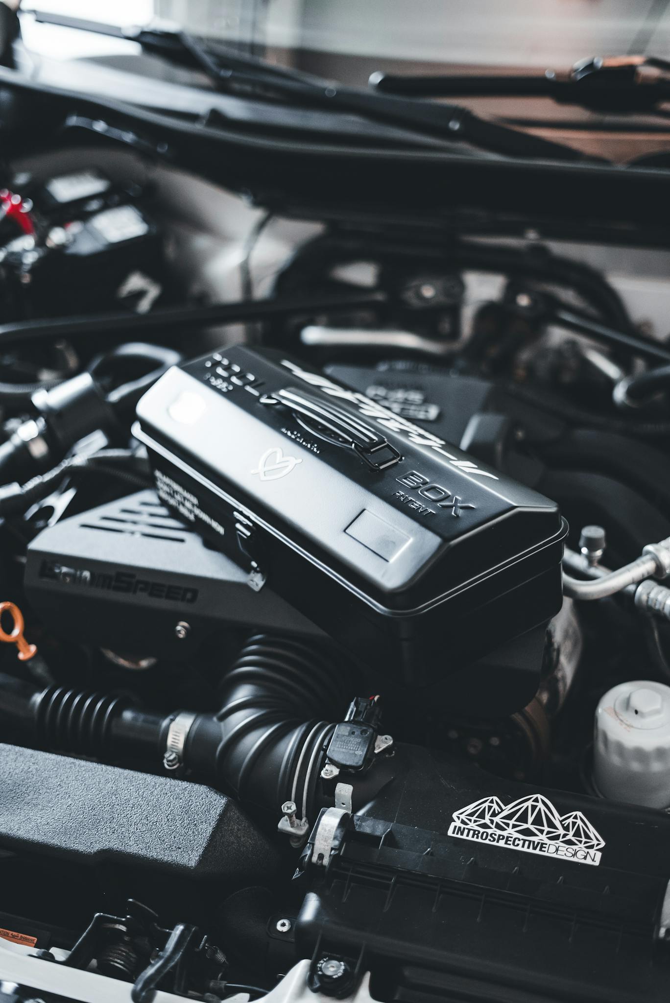 Detailed view of a high-performance car engine with a black box and sleek design components.